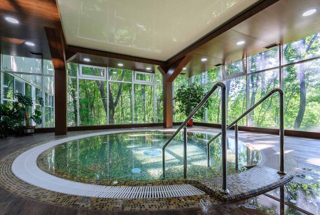 round indoor pool with steps and garden outside